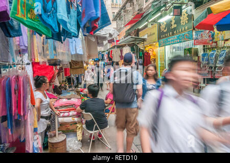 Die Menschen in der überfüllten Markt im Freien mit lebendigen Farben wie zahlreiche Händler, die eine Vielzahl von Waren und Dienstleistungen in Hongkong, China. Stockfoto