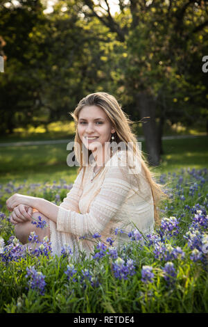 Mädchen das Lesen eines Buches in bluebonnet Blumen Stockfoto