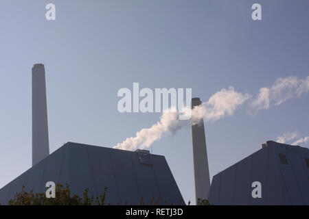 Modernes Kraftwerk mit Kamin und Rauch mit Hintergrundbeleuchtung gegen einen blauen Himmel mit Kopie Raum Stockfoto