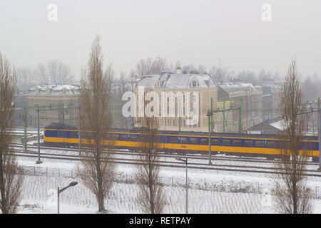 Amsterdam, Niederlande - 22 Januar 2019: Niederländische elektrische Intercity reiten durch Amsterdam im Schnee Blick von oben Stockfoto