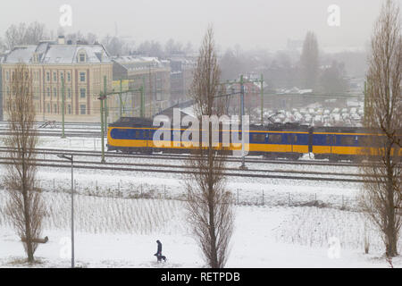 Amsterdam, Niederlande - 22 Januar 2019: Niederländische elektrische Intercity reiten durch Amsterdam im Schnee Blick von oben Stockfoto