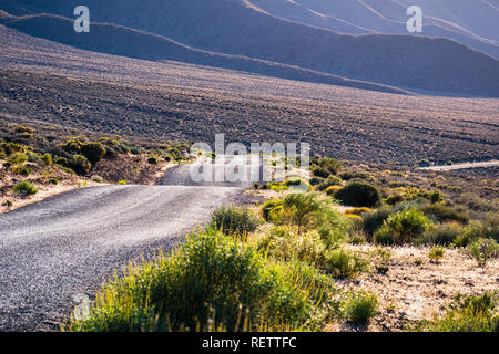 Emigrant Canyon Road gehen durch ein Tal in den Sonnenuntergang Licht getaucht, Death Valley National Park, Kalifornien Stockfoto