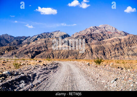 Fahren auf einer unbefestigten Straße gegenüber dem Eingang zum Titus Canyon, Death Valley National Park; steile Berge im Hintergrund; Kalifornien Stockfoto