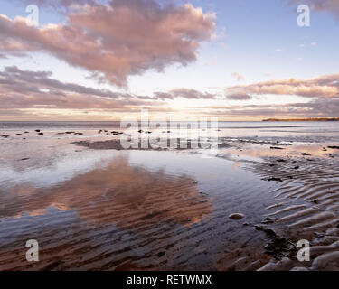 Malerische Aussicht über die Küstenlandschaft, im Vordergrund sand Rippen, über einige farbige Wolken, die im seichten Wasser reflektiert werden - Ort: Stockfoto
