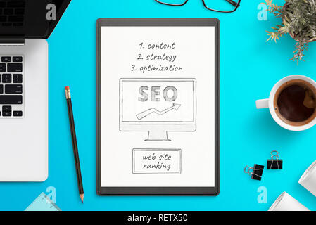 Search Engine Optimization Skizze auf weißem Papier. Büro Schreibtisch, Ansicht von oben Komposition. Laptop, Tasse Kaffee, Pflanze, Bleistift, Gläser neben. Stockfoto