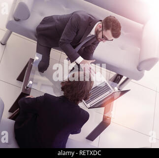 Zwei Geschäftsleute über Aufgaben im Büro sitzen. Stockfoto