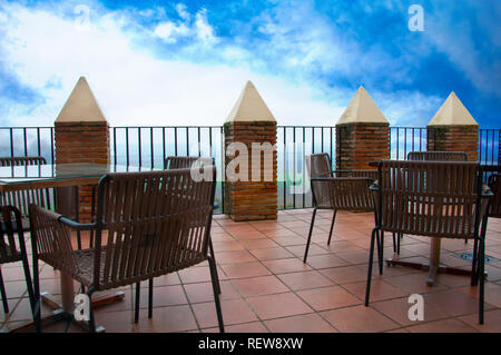 Tische und Stühle auf der großen Terrasse, blauer Himmel mit Wolken Stockfoto
