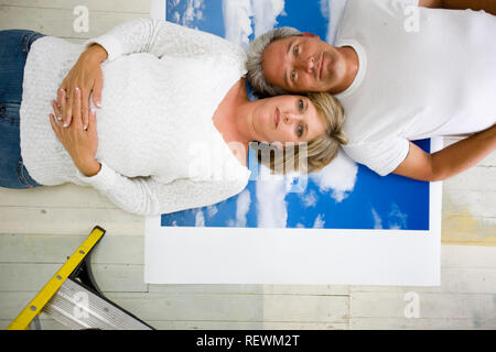 Porträt einer Mitte nach Paar nebeneinander gegen einen bewölkten Himmel Hintergrund liegt. Stockfoto