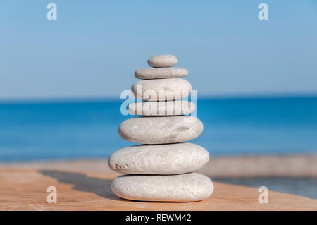 Stress locker mehrere Zen Steine auf unscharfen Meer und Strand Stockfoto