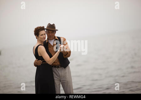 Portrait von ein paar Tanzen in der Nähe von auf das offene Meer auf einem nebligen Tag. Stockfoto