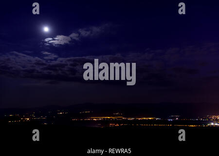 Nacht Stadtbild der Stadt Pancevo in Serbien. Moon, das leuchtet blau fast violett Wolken, straßenlaternen können an der Unterseite der Stadt gesehen werden. Stockfoto