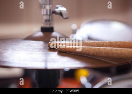 In der Nähe von ein paar Trommelstöcke liegen auf Becken. Stockfoto