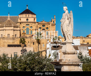 Steinerne Statue von Winkel auf dem Hintergrund der alten Gebäude der Stadt unter blauem Himmel in Cordoba, Spanien Stockfoto