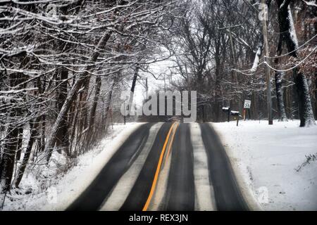 Wayne, Indiana, USA. Ein Land Schnellstraße während der Schnee zeigt Hinweise auf rutschigem Untergrund, wie es oben auf einem Hügel. Stockfoto