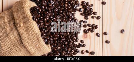 Verschüttete Kaffeebohnen aus Sackleinen Sack Stockfoto