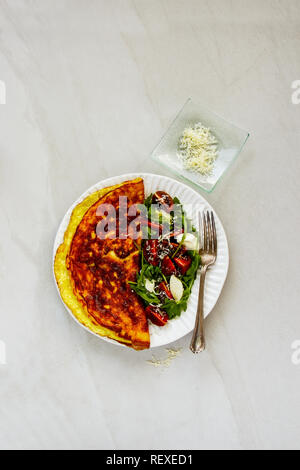 Frische Omelette mit italienische Caprese Salat und Parmesan Flachbild-lay Stockfoto