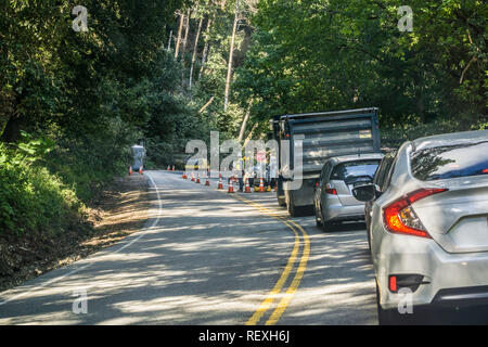 Mai 12, 2017 Saratoga/CA/USA - Autos warten durch eine Baustelle auf einer kurvigen Straße in einem Wald gelegen, San Francisco Bay Area. Stockfoto