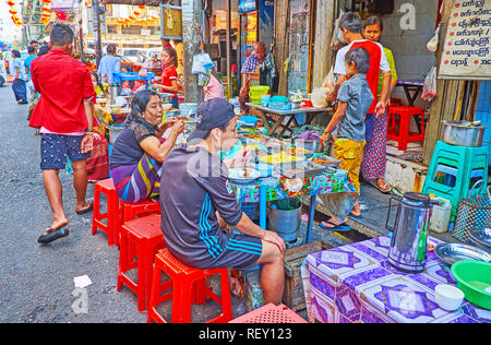 YANGON, MYANMAR - 17. FEBRUAR 2018: Die Einheimischen Abendessen im kleinen Café im Freien in Chinatown Markt genießen, am 17. Februar in Yangon. Stockfoto