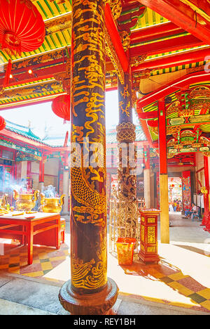 YANGON, MYANMAR - 17. FEBRUAR 2018: Die reich verzierte schwarze Säulen in Kheng Hock Keong (Qingfu) Tempel mit herrlichem Goldenen chinesische Drachen und andere mythische Stockfoto