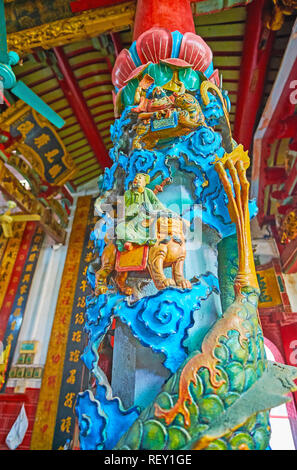 YANGON, MYANMAR - 17. FEBRUAR 2018: Die schwierigen Relief Spalte mit Schlange, Löwen und Gottheiten im Gebet Halle von Long Shan Tang Clan Tempel, Stockfoto