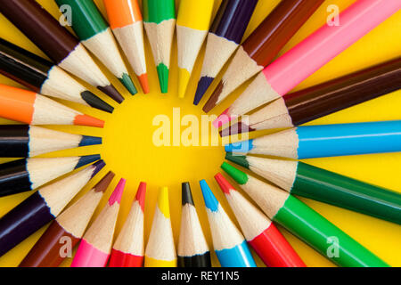 Ein Sortiment an Farbstifte im Kreis, Spirale auf gelben Hintergrund. Schulmaterial, Kreativität Konzept Stockfoto