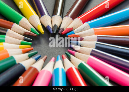 Ein Sortiment an Farbstifte im Kreis, Spirale auf schwarzen Hintergrund. Schulmaterial, Kreativität Konzept Stockfoto
