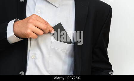Junger Mann nimmt Leere Visitenkarte aus der Tasche seines Shirt Stockfoto