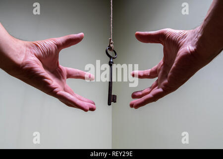 Menschen Hände greifen für Oldtimer Schlüssel hängen an einen String. Geschäftlicher Erfolg Freiheit Konzept Konzept für Bestrebungen, Leistung und Incentive Stockfoto