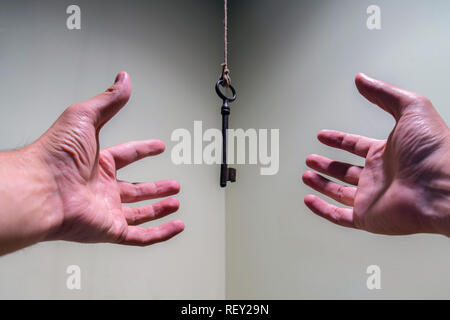 Menschen Hände greifen für Oldtimer Schlüssel hängen an einen String. Geschäftlicher Erfolg Freiheit Konzept Konzept für Bestrebungen, Leistung und Incentive Stockfoto