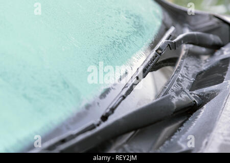 Ice Blüten, gefroren Auto Fenster. Die eiskalten Frost formen Eiskristalle in schöne einzigartige Muster auf dem Fenster, Haube und Wischer auf dem Auto Stockfoto