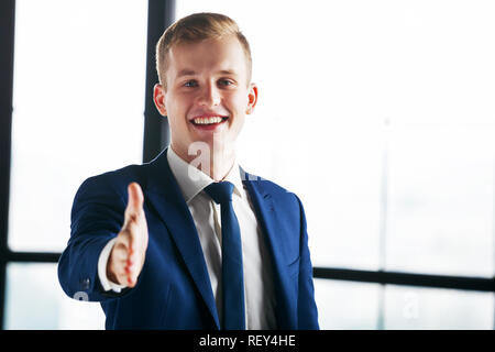 Glückliche junge Geschäftsmann mit Handshake erweitert. Stockfoto