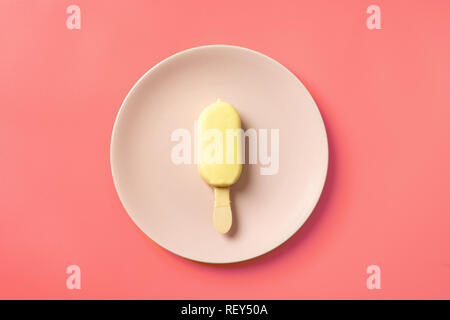 Ansicht von oben Eis popscicle in weißer Schokolade und auf rosa Platte Stockfoto