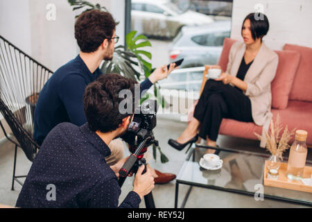 Ein Team von TV-Show ist die Aufnahme der Chat, der eine beliebte nodel mit einem Presenter Stockfoto