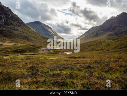 Den Pass von Glen Coe in den schottischen Highlands unter einem dramatischen Himmel Stockfoto