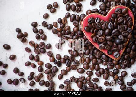 Kaffeebohnen in Herzform Teller/Valentines Tag Hintergrund Stockfoto