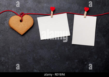 Valentinstag Grußkarten mit herzförmige Plätzchen und zwei Frames auf Stein Hintergrund. Ansicht von oben mit Platz für ihre Grüße. Flach Stockfoto