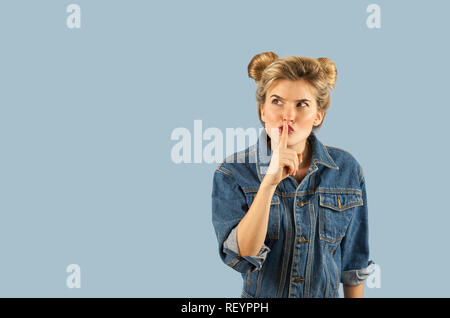 Junge schöne stark emotionalen Mädchen zeigt verschiedene Gesten auf einem blauen Hintergrund. Konzept der Menschlichen Emotionen Stockfoto