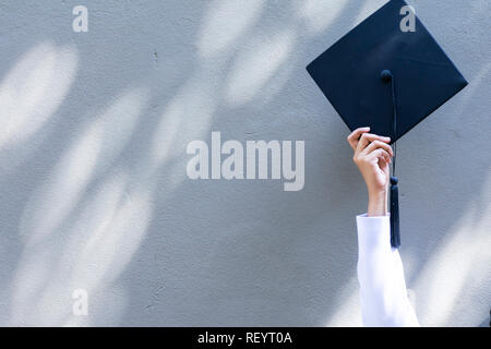 Staffelung Konzept. Erfolg in der Bildung ist der Anfang. die Absolventen an der Universität Abschlussfeier tragen mortarboard und Kleid. Sie hält Gra Stockfoto