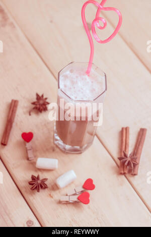 Kaffee mit Milch in ein Glas mit einem rosa Rohr. Die getränke Stockfoto