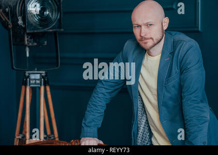 Portrait von attraktiven nach erfolgreichen Kahlen bärtiger Mann im Anzug auf der blauen Hintergrund, Blogging, TV-Host Stockfoto