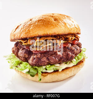 Schweinebauch Burger mit knusprigen Knistern auf einem Bett von Salat auf einem Getoasteten oder gegrillte knusprige Brötchen über Weiß für ein Menü oder Werbung Stockfoto