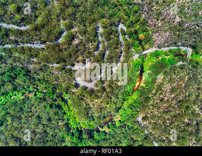 Serpentine twisted Galston Straße auf steilen Hügel Seite nach unten zu Berowra Creek in einem Tal durch Gummi-tree Woods mit starkem Verkehr gesehen von oben oben d Stockfoto