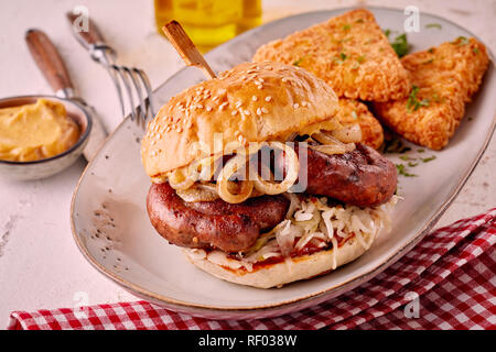 Sesambrötchen mit Wurst und Zwiebeln auf dem Teller serviert. Stockfoto