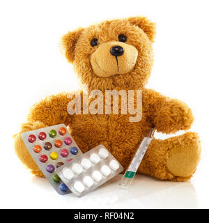 Sick toy Teddybär mit Blister von Tabletten und ein Thermometer über einer reflektierenden weißen Hintergrund in ein Konzept der pädiatrischen Healthcare Stockfoto