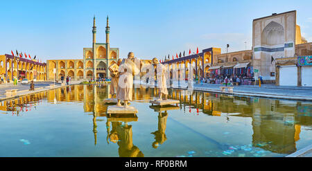 YAZD, IRAN - 18. OKTOBER 2017: Panorama von Amir Chakhmaq Platz mit Reflexion der Wahrzeichen (Hosseinieh, Skulptur Moschee und Wasserträgerinnen') in Stockfoto