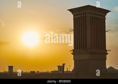 Genießen Sie romantische Sonnenuntergänge über den Dächern der historischen Fahadan Bezirk mit Blick auf den mittelalterlichen badgirs (windcatchers) und feurigen Himmel, Yazd, Iran. Stockfoto