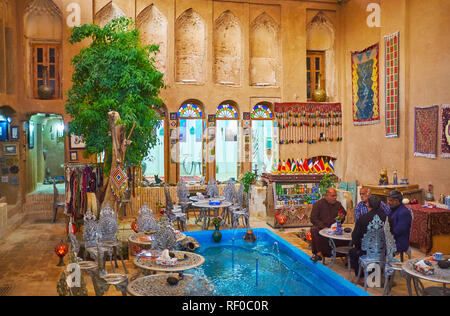 YAZD, IRAN - 18. OKTOBER 2017: Innere der alten Restaurant, in den Innenhof des Adobe Herrenhaus mit dem Brunnen zwischen den Tischen, Oktober Stockfoto