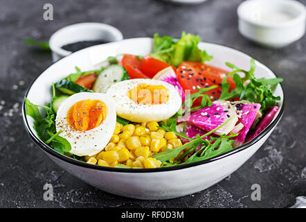 Frischer Salat. Schale mit frischen, rohen Gemüse: Gurke, Tomate, Wassermelone Radieschen, Kopfsalat, Rucola, Mais und gekochtem Ei. Gesundes Essen. Vegetarische Bud Stockfoto