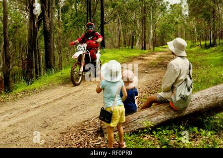 Dirt Bikes reiten auf einem Feuer auf der Straße draußen im Wald, Mia Mia State Forest, Queensland, Australien Stockfoto