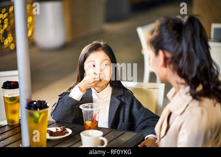 Asiatische Mutter und Tochter reden Chatten in Getränken und Desserts Stockfoto